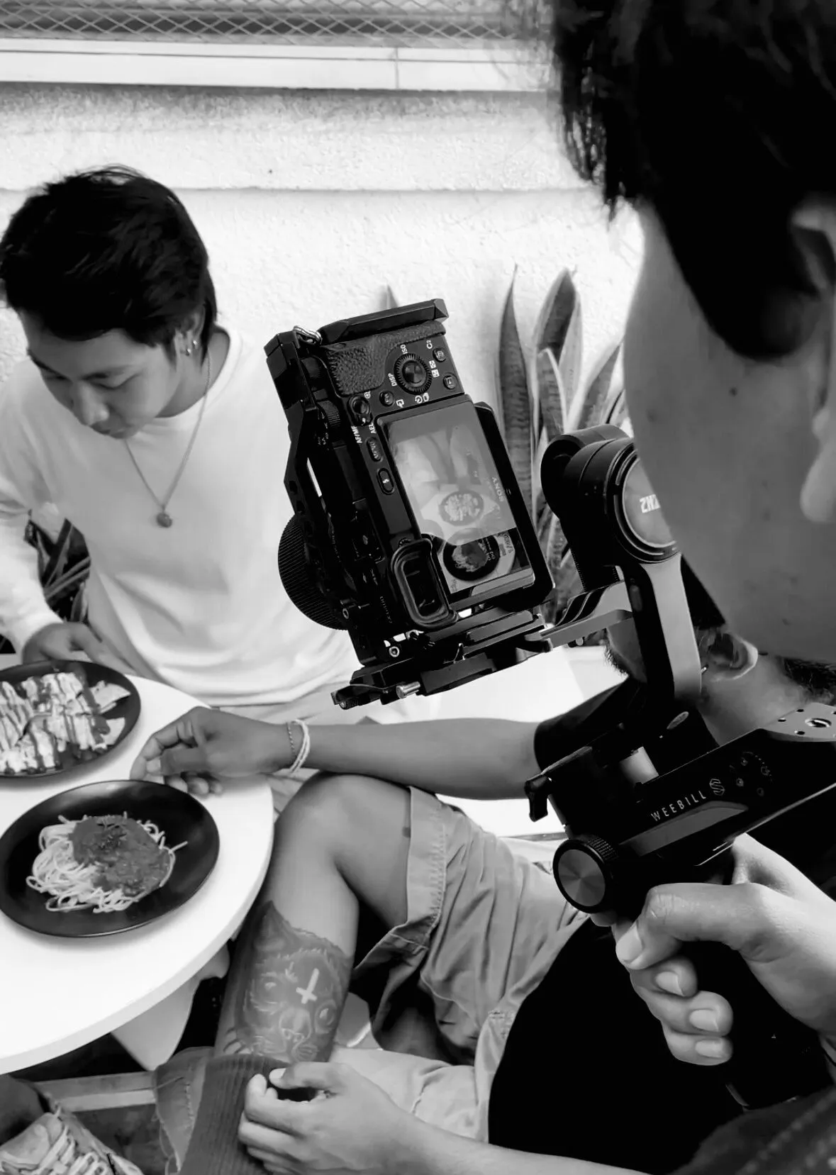 A camera operator working on a food scene